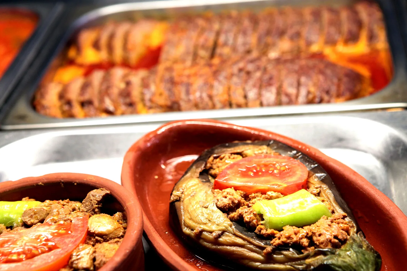 Gevulde aubergine en paprika in aardewerken schaaltjes