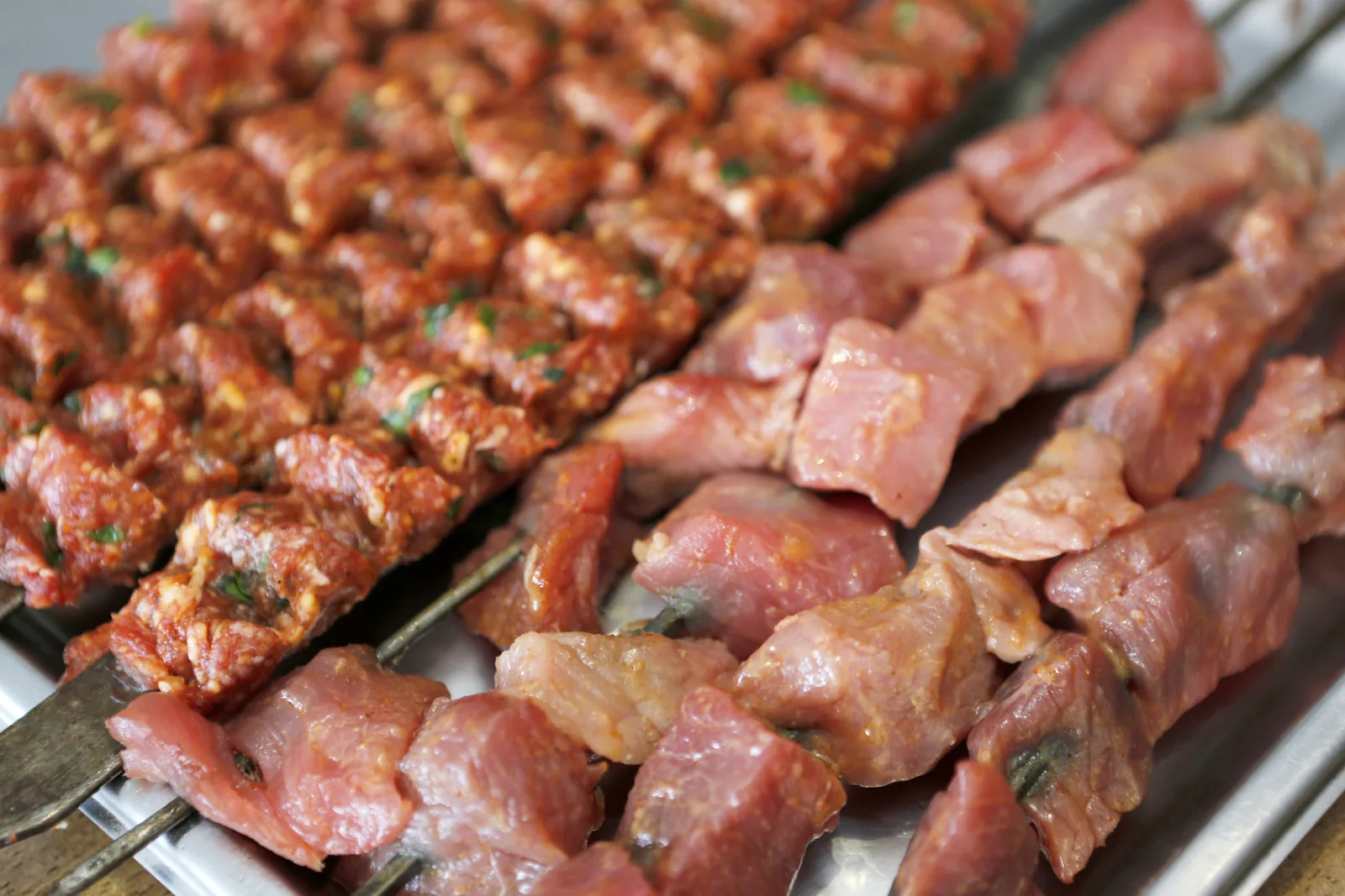 Verse brochettes en gemarineerd vlees klaar voor de grill bij Sifa